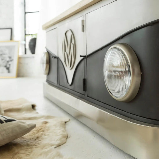 Decorative item resembling a vintage vehicle headlight on a shelf with a blurred background