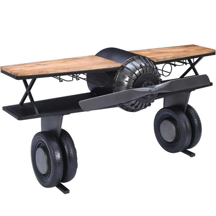 Industrial airplane-engine style bar cart with propeller decoration and dual shelves, featuring wooden tabletop, black metal frame, large rubberized wheels, hanging wine-glass rack and storage for bottles, set in a modern living-room environment