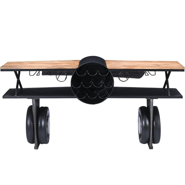 Industrial airplane-engine style bar cart with propeller decoration and dual shelves, featuring wooden tabletop, black metal frame, large rubberized wheels, hanging wine-glass rack and storage for bottles, set in a modern living-room environment