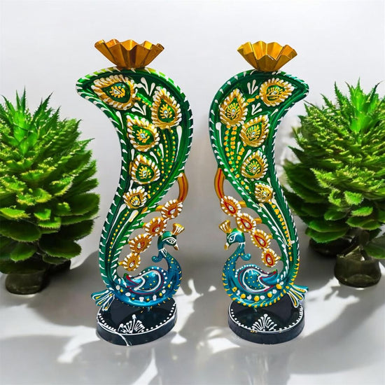 Decorative candle holders with peacock designs on a white background