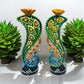 Decorative candle holders with peacock designs on a white background