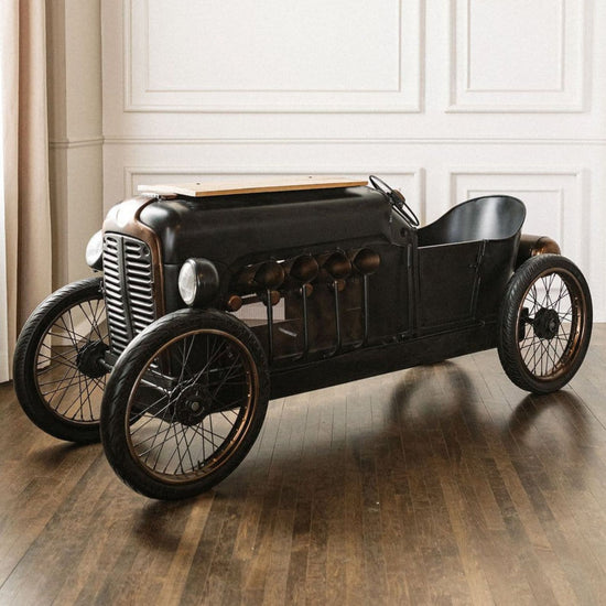 Vintage-style toy car on a wooden floor with a neutral background