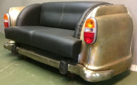 Sofa designed like a vintage car with black leather seats and gold body.