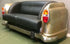 Sofa designed like a vintage car with black leather seats and gold body.