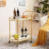 Gold bar cart with wine bottles and snacks in a living room setting