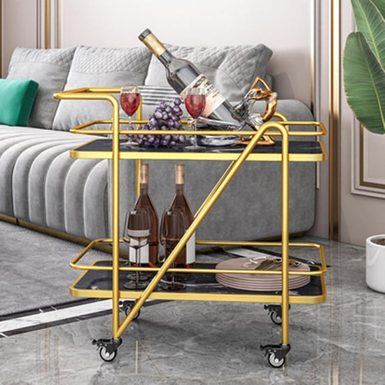 Gold bar cart with wine bottles and glasses in a living room setting