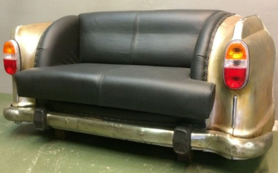 Sofa made from a car body with black leather upholstery and car parts.