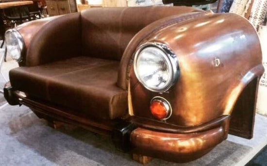 Brown leather sofa designed like a vintage car with headlights and license plate.