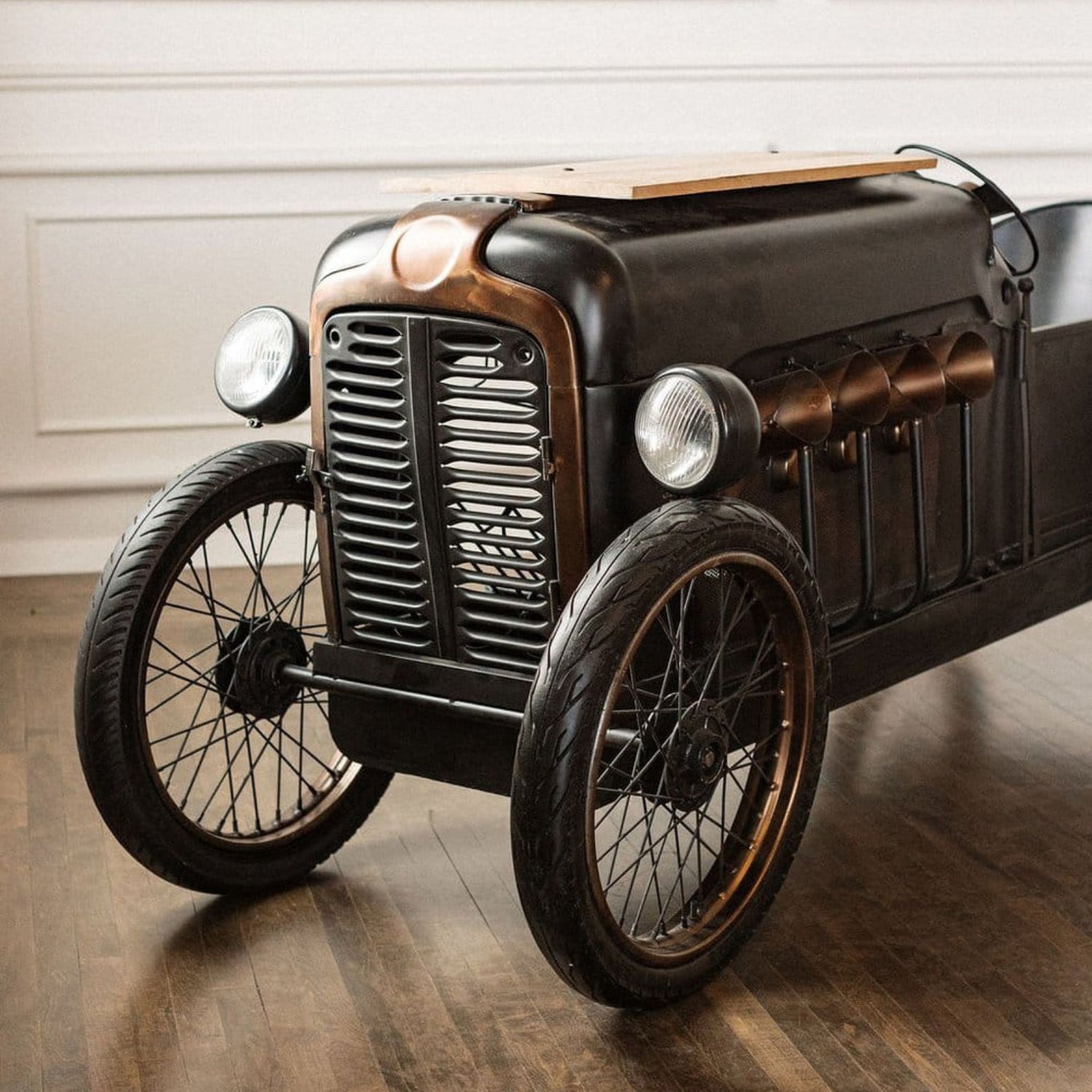 Vintage-style motorcycle on a wooden floor with a neutral background
