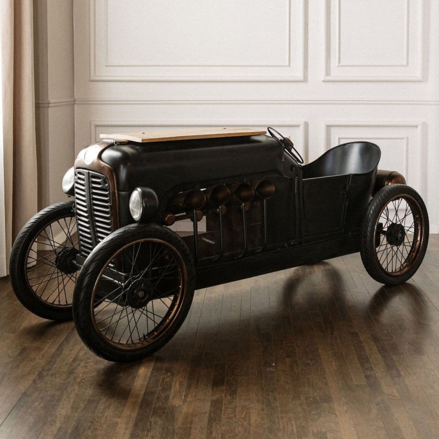 Vintage-style toy car on a wooden floor with a neutral background