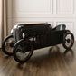 Vintage-style toy car on a wooden floor with a neutral background