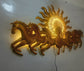 This Designer Gold metal wall art features a stunning depiction of 7 galloping horses against a warm sun backdrop. At 48 x 28 inches, it is sure to make a statement in any room. The integrated LED lights add a touch of modernity and ambiance. Perfect for any equestrian enthusiast.  Size: 48 x 28 Inches.  Made of High-Quality Iron Metal Anti-rust powder coating used for long lasting finish Hanging Mechanism included Horse wall decor with led lighting Perfect for your living room, bedroom, hall, office recept