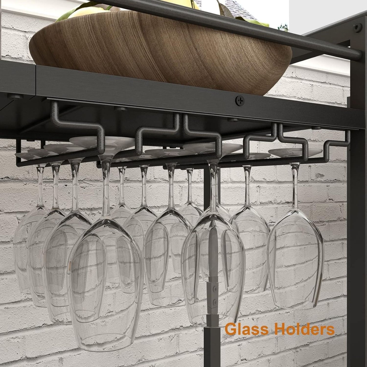 Black wine glass holder with hanging glasses against a light brick wall.