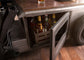 Bottles of alcohol in a wooden crate under an open cabinet door.