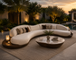 Modern outdoor sofa with decorative pillows and a coffee table in a garden setting during sunset.